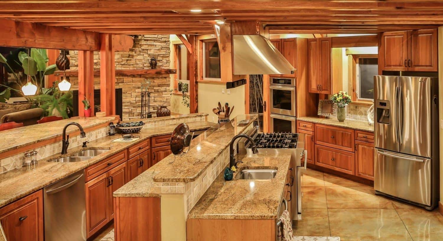 Large kitchen with stamped concrete flooring, wooden cabinets, stone countertops, and stainless steel appliances